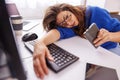 Tired woman leaning on her desk while working overtime in home office Royalty Free Stock Photo