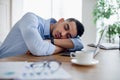 Tired Arab businessman sleeping on his desk in front of laptop, overworking, feeling exhausted in modern office Royalty Free Stock Photo