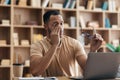 Tired arab male freelancer working on laptop from home office and taking off glasses, sitting at desk Royalty Free Stock Photo