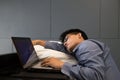 Tired Asian businessman sleeping on a laptop with pillow Royalty Free Stock Photo