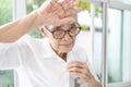 Tired asian elderly woman have headaches,check her body temperature,touching forehead with her hand,feel hot,dizzy,concerned about Royalty Free Stock Photo