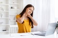 Tired Asian Freelancer Woman With Neck Pain Sitting At Desk With Laptop