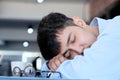 Tired asian man sleeping at office desk. Young businessman with eyeglasses overworked and fell asleep, Creative casual man