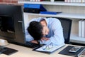 Tired asian man sleeping at office desk. Young businessman with eyeglasses overworked and fell asleep, Creative casual man