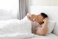 Tired asian man yawning while waking up in his bedroom Royalty Free Stock Photo