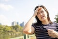 Tired asian woman with headache,dizziness,walking outdoor on sunny day,strong sunlight,hot weather,high temperature heat wave, Royalty Free Stock Photo