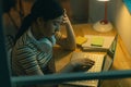 Tired Asian woman trying to get work done at night Royalty Free Stock Photo