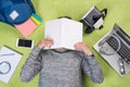 Tired asian young man with a book on his face lying on the floor Royalty Free Stock Photo