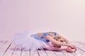 Tired ballet dancer lying on the wooden floor Royalty Free Stock Photo