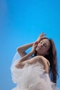 Tired ballet dancer sitting over blue studio background Royalty Free Stock Photo