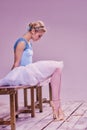 Tired ballet dancer sitting on the wooden floor Royalty Free Stock Photo