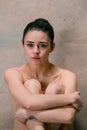 Tired ballet dancer sitting on the wooden floor on a pink background Royalty Free Stock Photo