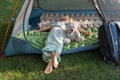 tired barefoot child sleeps or rests lying on his stomach in a tent with his favorite toy teddy bear