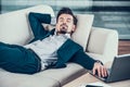 Tired bearded businessman asleep on sofa in office Royalty Free Stock Photo