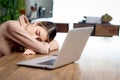 Tired beautiful Asian woman worker sleeping on her workplace during working on laptop computer at home, exhausted female worker Royalty Free Stock Photo