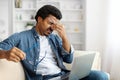 Tired black man rubbing eyes, showing signs of fatigue after using laptop Royalty Free Stock Photo