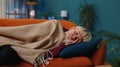 Tired blonde young woman lying down in bed taking a rest at home, napping falling asleep on sofa Royalty Free Stock Photo