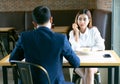 Tired bored Asian girl sitting and lunch with her boyfriend at a cafe and looking away.Young emotional couple get quarreled in Royalty Free Stock Photo