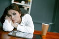 Tired or bored business woman relax at workplace. Young Caucasian woman rest at office table with coffee paper cup and Royalty Free Stock Photo