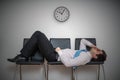 Tired bored man is sleeping in waiting room on chairs.