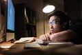 Tired bored man studying using books and computer at nighttime Royalty Free Stock Photo