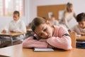 Tired bored teenage schoolgirl sleeping at desk closeup Royalty Free Stock Photo