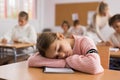 Tired bored teenage schoolgirl sleeping at desk closeup Royalty Free Stock Photo