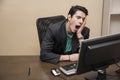 Tired bored young businessman sitting in office Royalty Free Stock Photo