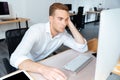 Tired bored young businessman working with computer in office Royalty Free Stock Photo