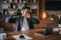 Tired boring adult korean man manager in glasses and headphones yawns and rests from work