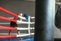 Tired boxer resting in boxing ring, head on gloves
