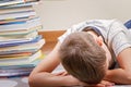 Tired boy near big stack of books. Royalty Free Stock Photo