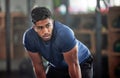 Tired, breathing and fitness gym man taking a break from workout, training or exercising inside a wellness center. Young