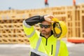 Tired builder, hard work concept. Worker in building uniform on buildings construction background. Builder at the
