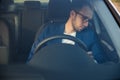 Tired business man falling asleep sitting inside her car seen through windshield Royalty Free Stock Photo