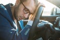 Tired business man falling asleep sitting inside her car seen through windshield Royalty Free Stock Photo