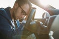 Tired business man falling asleep sitting inside her car seen through windshield Royalty Free Stock Photo