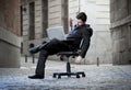 Tired Business Man sitting on Office Chair on Street sleeping Royalty Free Stock Photo