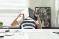 Tired business man sleeping at his desk covering his head with  laptop Royalty Free Stock Photo