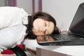 Tired business woman fell asleep next to a laptop