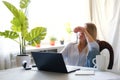 Tired business woman looking at mobile phone while at home in office work space Royalty Free Stock Photo