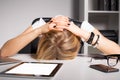 Tired business woman resting her head on desk