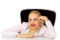 Tired business woman sitting behind the desk Royalty Free Stock Photo