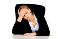 Tired business woman sitting behind the desk Royalty Free Stock Photo