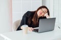 Tired business woman sleeping at desk at work in front of laptop Royalty Free Stock Photo