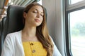 Tired business woman sleeping sitting in the train after a day of work . Train passenger traveling sitting relaxed and sleeping Royalty Free Stock Photo