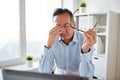 Tired businessman with glasses at laptop in office Royalty Free Stock Photo