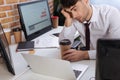 young businessman sitting near computers, smartphone