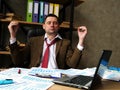 Tired businessman relaxes and meditates while sitting at the office desk Royalty Free Stock Photo