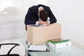 Tired Businessman Resting On Cardboard Box At Desk Royalty Free Stock Photo